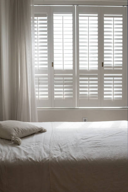 istock White themed bed sheets and white curtain, bedroom interior. 1322459034