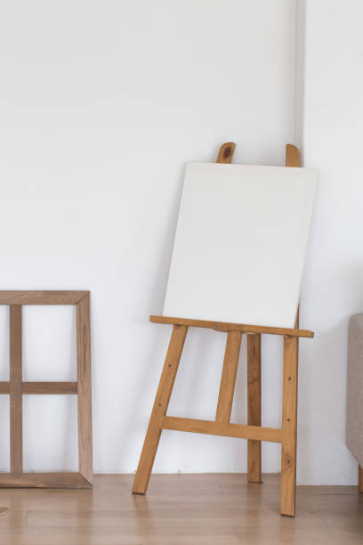 istock Wooden empty easel in the room interior. 1322459043