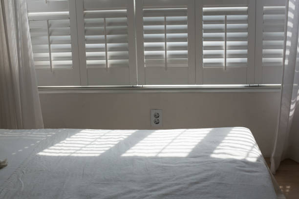 istock White themed bed sheets and white curtain, bedroom interior. 1322459057