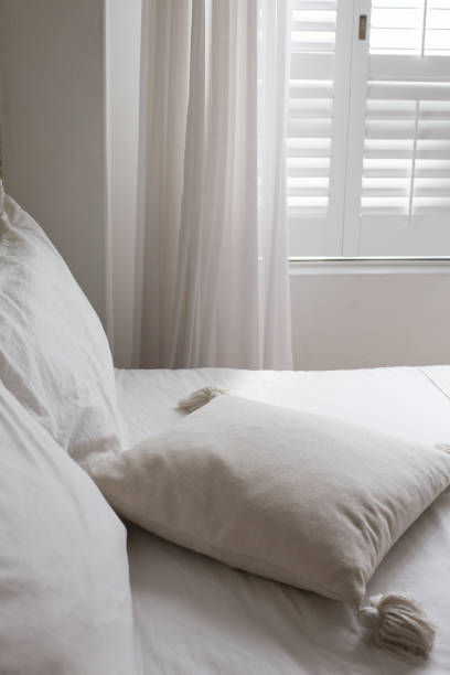 istock White themed bed sheets and white curtain, bedroom interior. 1322459077