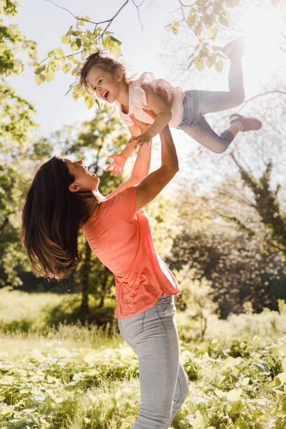 istock Cheerful single mother and her small daughter having fun in nature. 1322459122