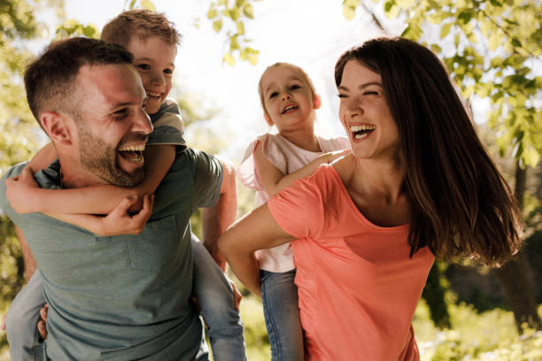 istock Playful family having fun while piggybacking in springtime. 1322459435