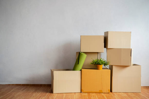moving in. stack of cardboard boxes in the empty room - real estate imagens e fotografias de stock