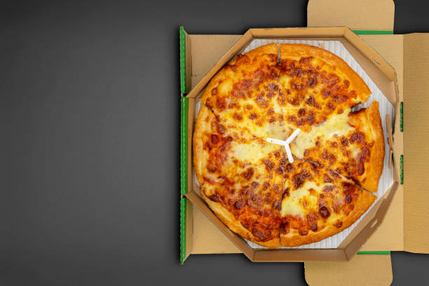 istock Pizza in a cardboard box on a black chalkboard background. Space for text. 1322459775