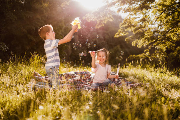 istock Happy little kids making bubbles in spring day at the park. 1322461083