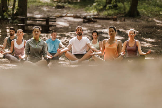 istock Large group of athletes having Yoga class in nature. 1322461552