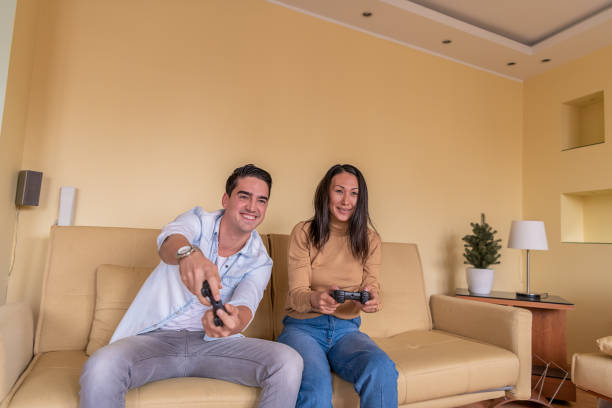 istock Handsome Young Man and his Asian Girlfriend are Having Fun with Video Games. 1322462473