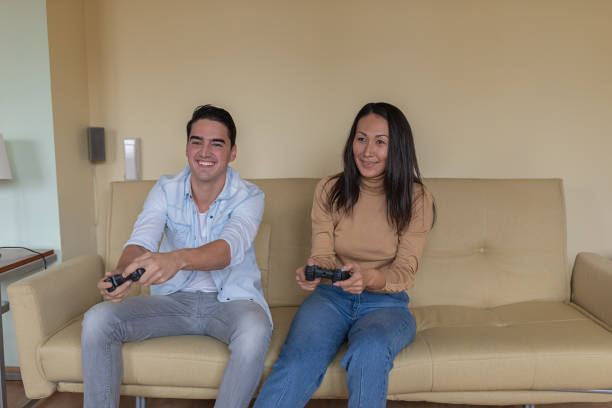 istock Handsome Young Man and his Girlfriend of Chinese Ethnicity are Playing Game Console While Spending Time Together at Home. 1322462546