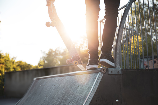 Skater standing on a ramp in skatepark in sunny day