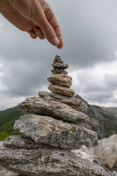 istock Detail of hand stacking rocks on a mountain top 1322463954
