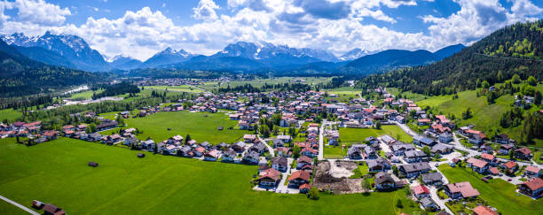 istock Wallgau Bavarian Alps. Aerial Panorama Shot. Mountains, clouds, fields, village 1322464676