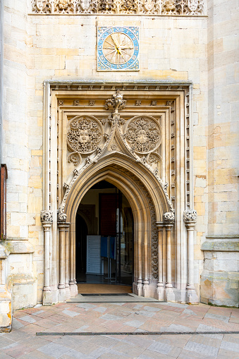 The ornate carved stone entrance to Great St Mary's Church in Central Cambridge, England, UK.  Above it is a clock face.