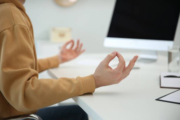 istock Man meditating at desk in light office, closeup 1322466407