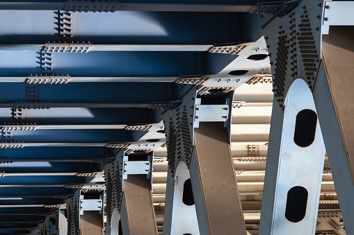 Metal supports of the bridge carrying heavy road - closeup view of bridge substructure
