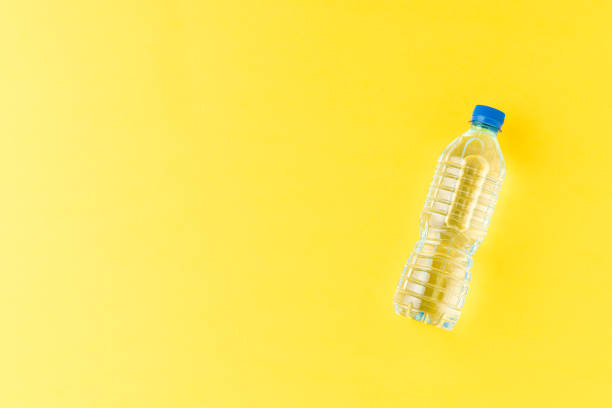 istock Overhead shot of plastic bottle with water on yellow table with copyspace. Flat lay 1322470442