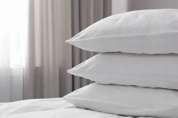 White soft pillows on bed. Space for text