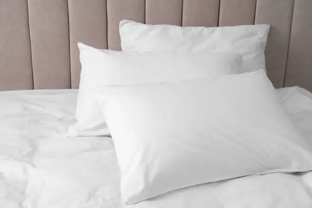 White soft pillows on comfortable bed indoors