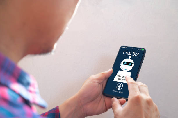 istock Casual business man chatting with chatbot via mobile smart phone application while working 1322472709