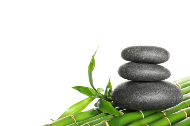 istock Stack of spa stones on bamboo stems against white background 1322473116