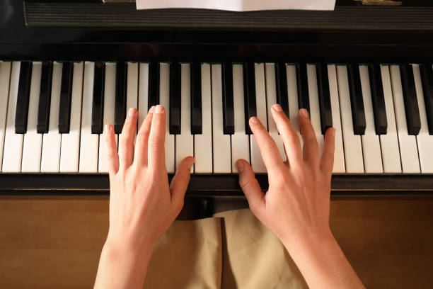 istock Young woman playing piano, above view. Music lesson 1322473191
