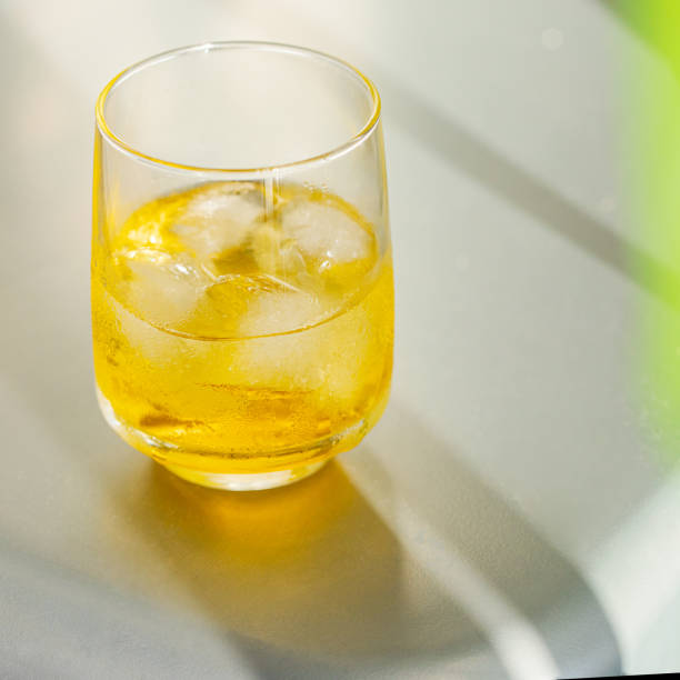istock Refreshing cocktail with  ice on white background with palm tree leaf. 1322478323