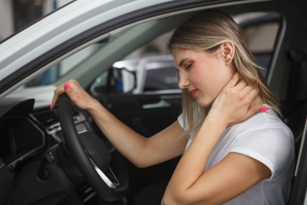 Woman having neck pain Young woman suffering from neck whiplash, sitting in drivers seat of her car car accident stock pictures, royalty-free photos & images
