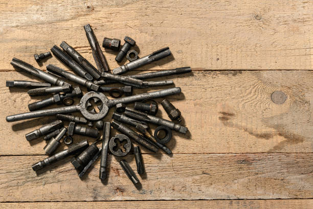 Old vintage drills and threading die tools on a wooden background