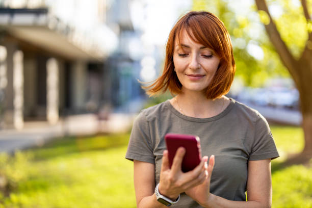 Smiling woman using a smartphone in the city