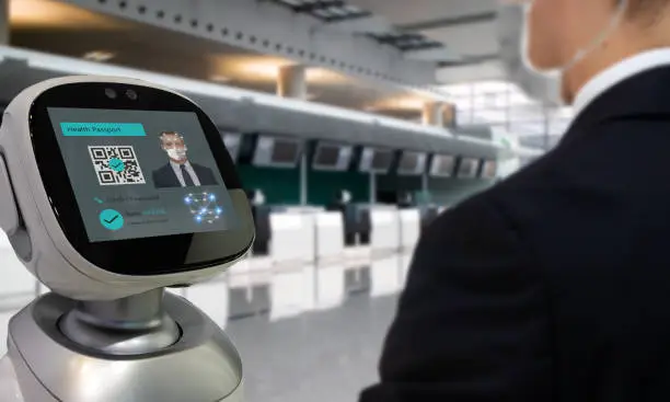 Photo of Smart hospitality industry concept, airport or hotel using robot to  scan and personal data check with customer who got covid-19 vaccinate by using face recognition detection technology