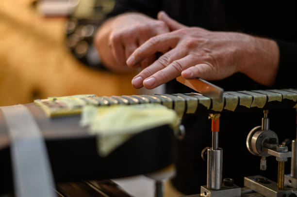 guitarra eléctrica negra en taller de reparación con una mano de un luthier de guitarra - fabricante de instrumentos fotografías e imágenes de stock