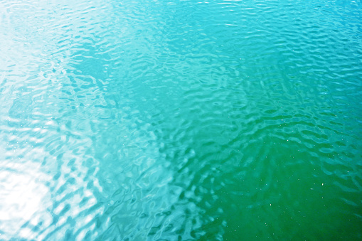 Background texture or small ripple waves in the calm green ocean water