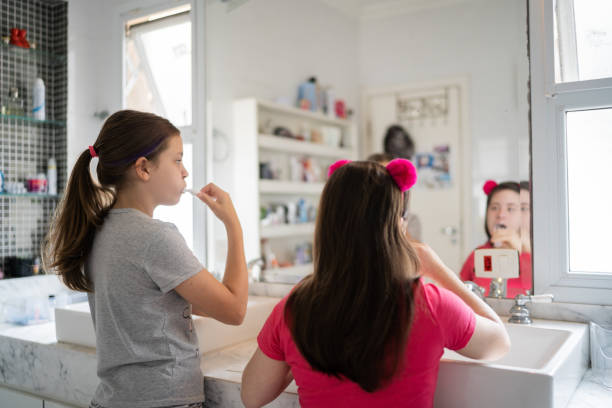 istock Sisters brushing teeth together at home - including a special needs girl 1322491415