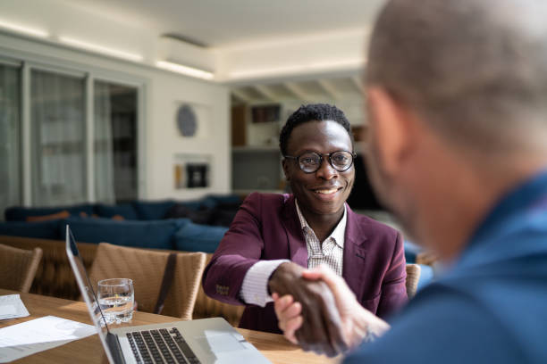 Real estate shaking hands with customer setting a deal at home