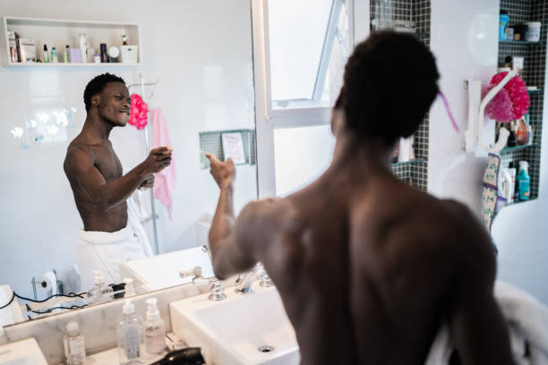Happy young man dancing in front of mirror in the morning at home Happy young man dancing in front of mirror in the morning at home vanity mirror photos stock pictures, royalty-free photos & images
