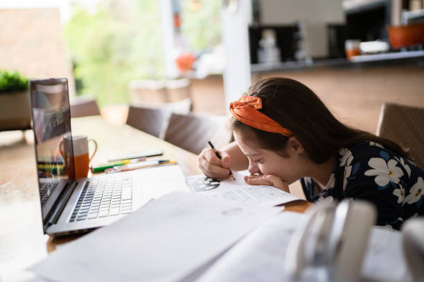 istock Special needs girl studying using laptop at home 1322492774