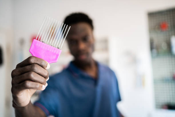 Portrait of a young man showing afro comb