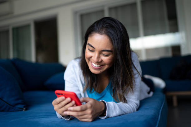 istock Happy young woman using smartphone at home 1322493023