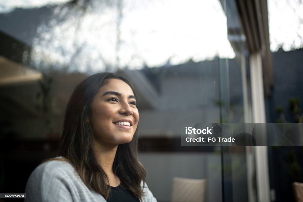 Young woman contemplating at home Happy young woman contemplating at home Mental Health Stock Photo