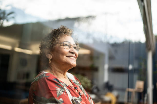 mujer mayor contemplando en casa - tercera edad fotografías e imágenes de stock