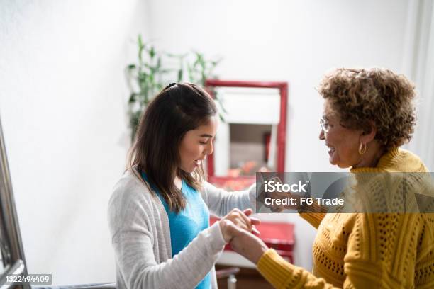 Nurse Supporting Senior Patient Walking Or Moving Up The Stairs At Home Stock Photo - Download Image Now