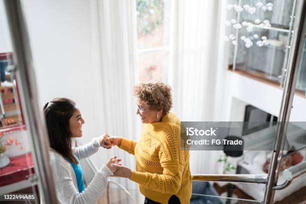 Nurse Supporting Senior Patient Walking Or Moving Up The Stairs At Home Stock Photo - Download Image Now