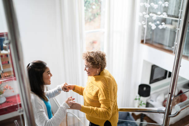 nurse supporting senior patient walking or moving up the stairs at home - senior adult home caregiver care community outreach imagens e fotografias de stock