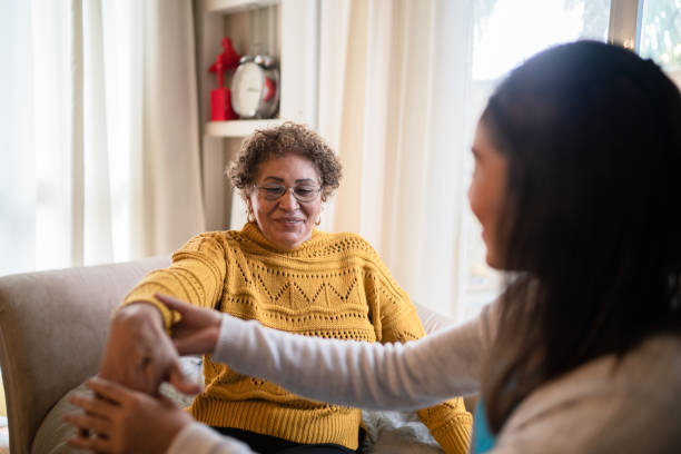 istock Physical therapist helping senior woman doing exercise at home 1322495719