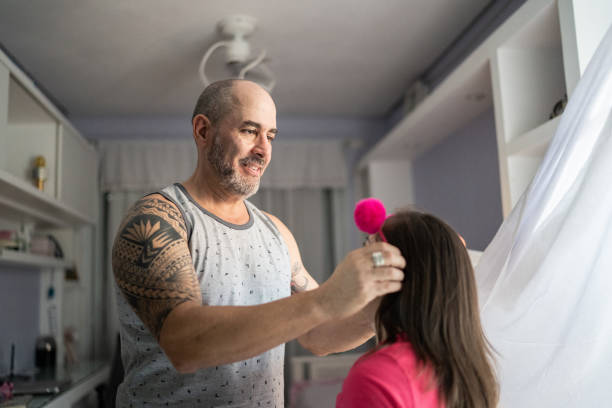istock Father putting a tiara on daughter's hair at home 1322496236