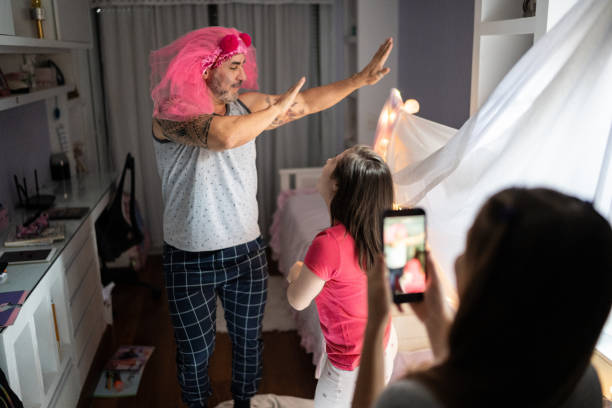 istock Father having fun dancing with daughters and filming it at home - girl with special needs 1322496768