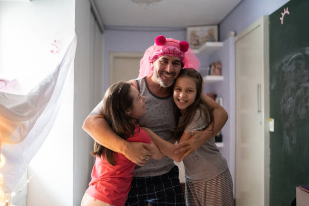 istock Father playing with daughters and embracing them - girl with special needs 1322496783