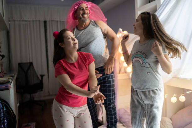 istock Father and daughters dancing having fun together at home - girl with special needs 1322496840