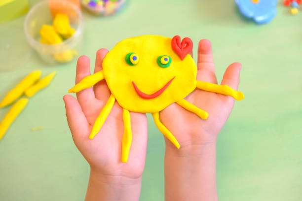 child playing with plasticine, colorful modeling clay and sculpting funny sun . - craft valentines day heart shape creativity imagens e fotografias de stock