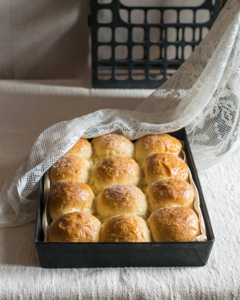 istock Homemade bread rolls in baking tin mold on linen tablecloth. Selective focus 1322497322
