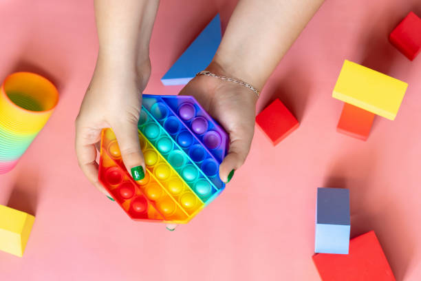 istock female hand playing with rainbow toy antistress pop it 1322498315